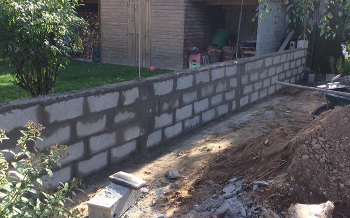 Mur en parpaings en cours de construction dans un jardin à Rezé